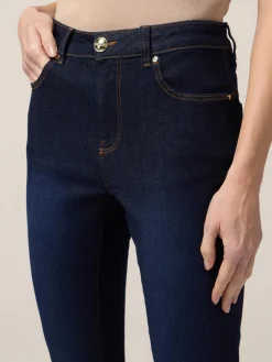 Jeans skinny blu rinse con bottoni sul fondo gamba